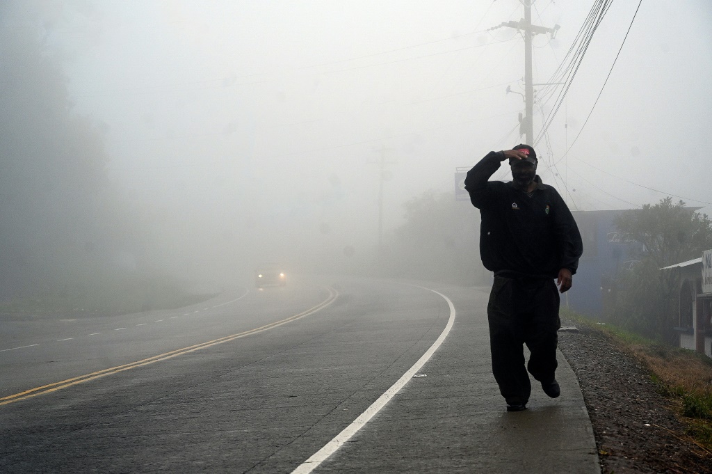 A man walks along a road in the town of Santa Ana, in Honduras's Francisco Morazan department, on October 9, 2022, shortly before the arrival of Hurricane Julia