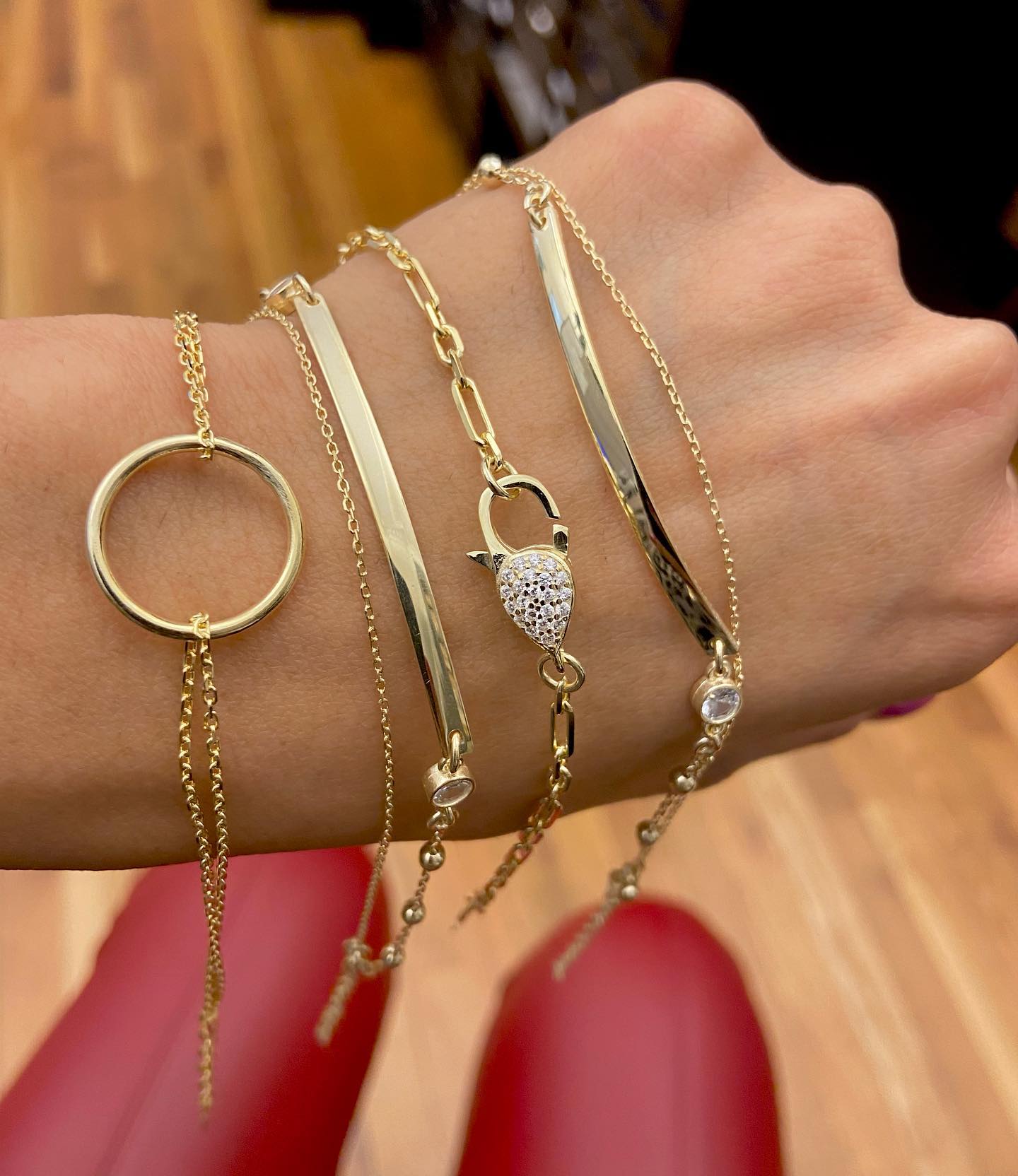 A wrist adorned with multiple gold bar bracelets