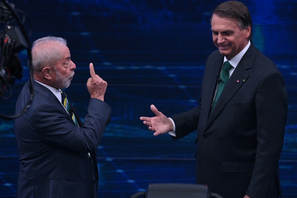 Former president Luiz Inacio Lula da Silva (L), and President Jair Bolsonaro (R) gesture during a televised debate ahead of Brazil's runoff election in two weeks