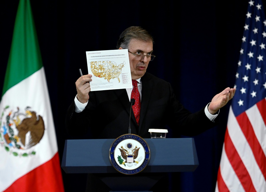 Mexican Foreign Secretary Marcelo Ebrard, speaking at a press conference at the US State Department, holds a map of American counties that sell the most number of weapons that end up seized in Mexico