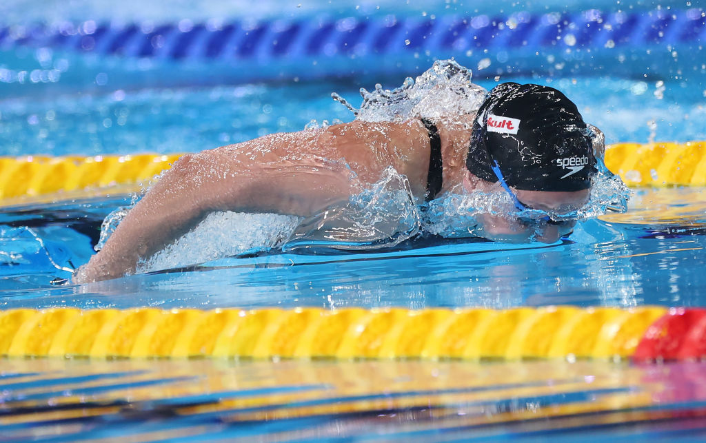 A swimmer wearing a headband in a pool, gracefully gliding through the water.