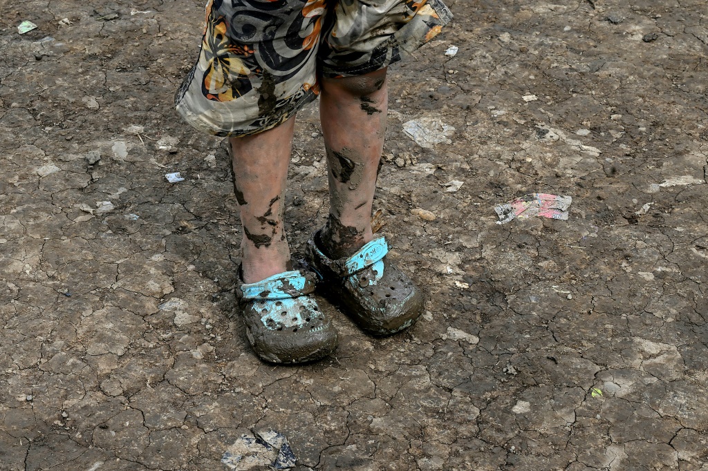 The shoes of a Venezuelan migrant girl are coated in mud after traveling through the Darien Jungle