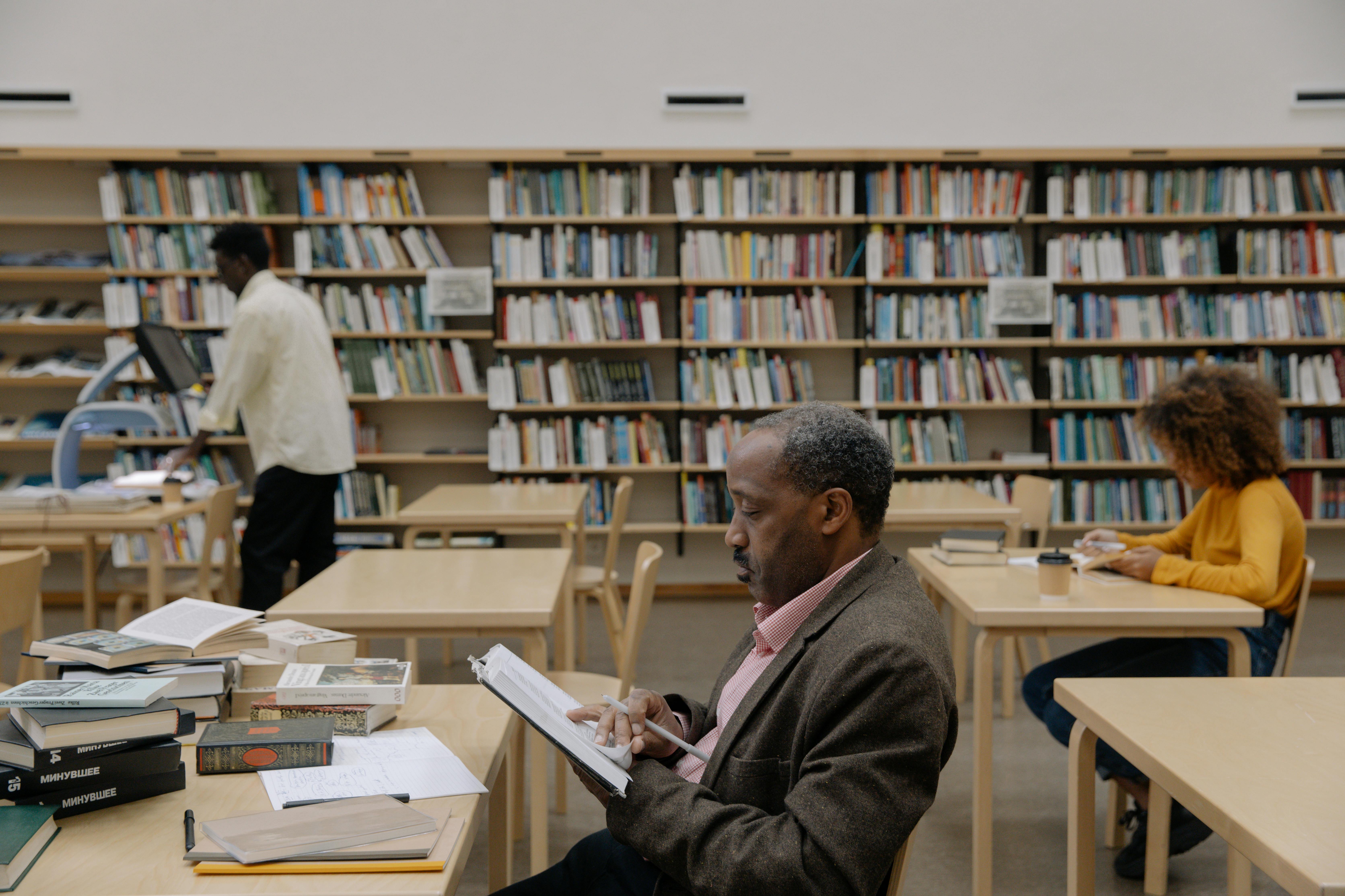 A picture of a man and a lady reading in the library