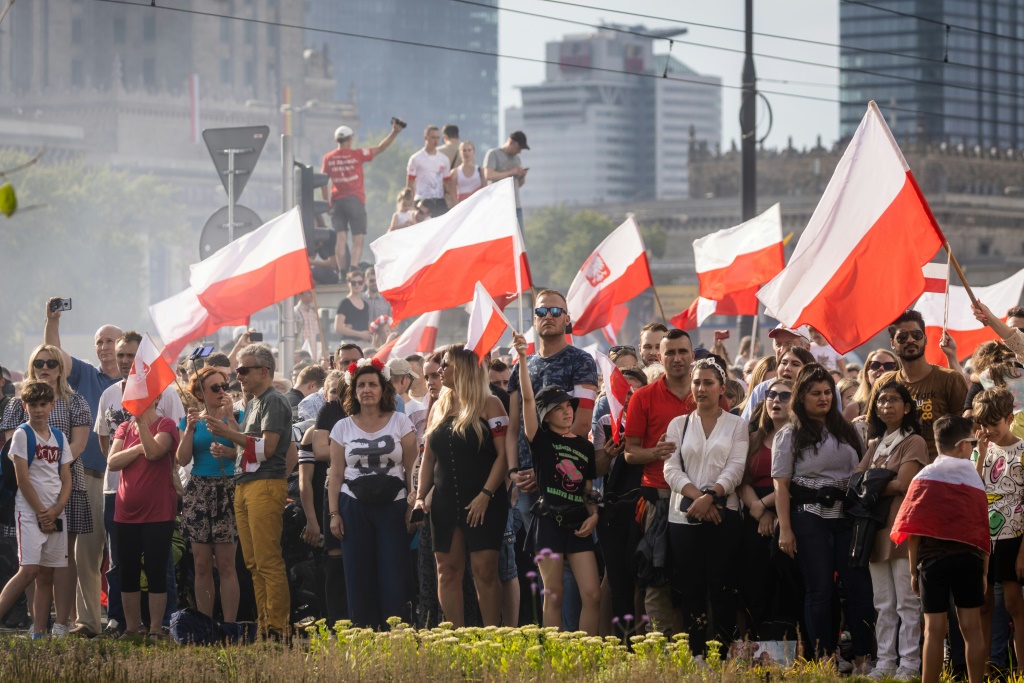 People wave Polish flags during an event on August 1, 2022 to mark the 78th anniversary of the Warsaw Uprising