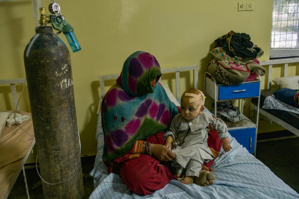 A woman cradles an injured child at the Sharan Hospital in Paktika province