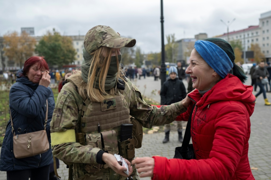 A woman greets a Ukrainian soldier as local residents gathered to celebrate the liberation of Kherson on Sunday