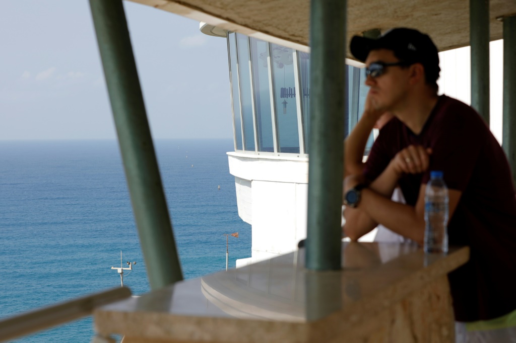 A man looks out to sea towards maritime border markers in Mediterranean waters off Israel's crossing at Rosh Hanikra, known in Lebanon as Ras al-Naqura