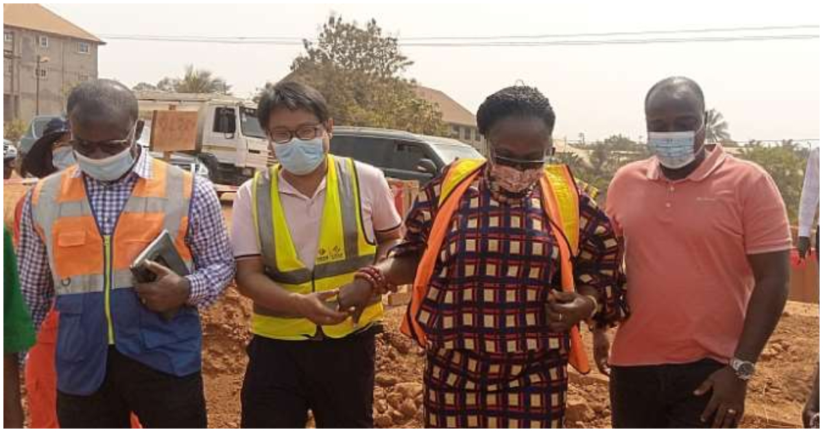Mad. Owusu-Banahene inspects the construction site of the road project with contractors