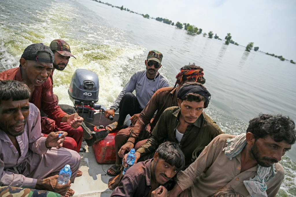 Pakistan navy volunteers cruise the newly formed lake in lifeboats to reach stranded villagers