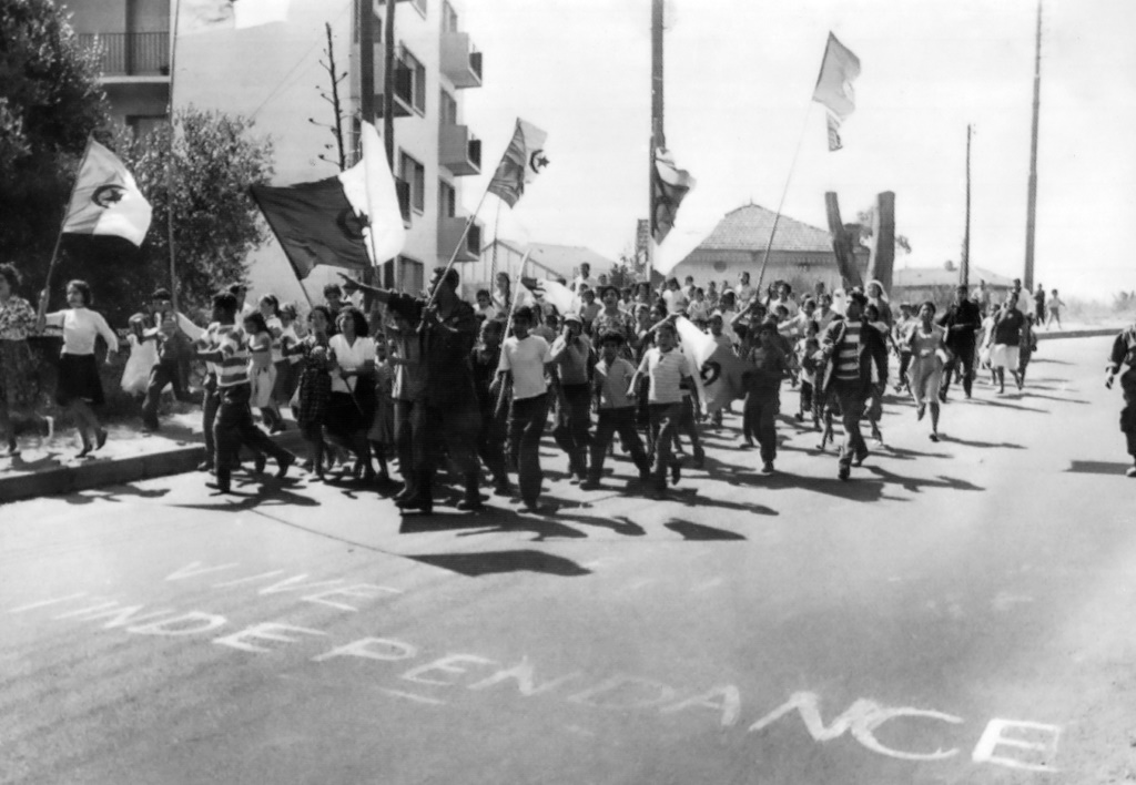 Young Algerians marching between the European and Muslim quarters of Algiers, waving Algerian flags, celebrate independence of Algeria on July 2, 1962 one day after the self-determination referendum on the independence of Algeria
