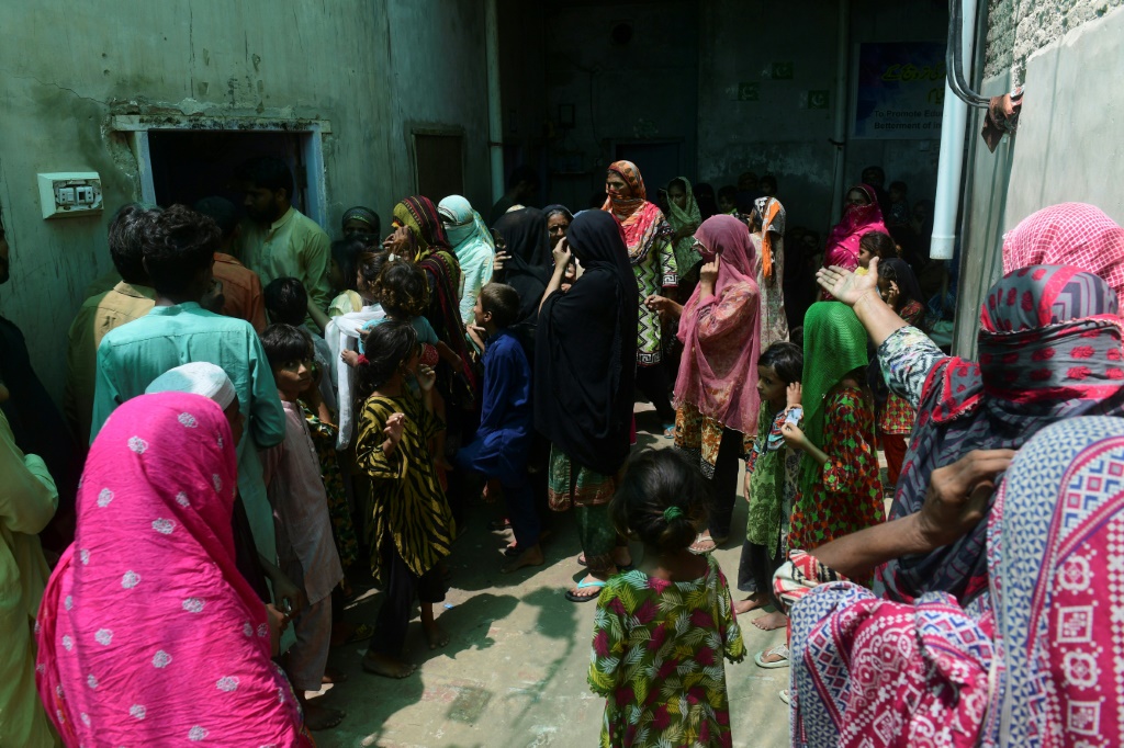 People queue to receive medical attention at a medical camp on the outskirts of Sukkur