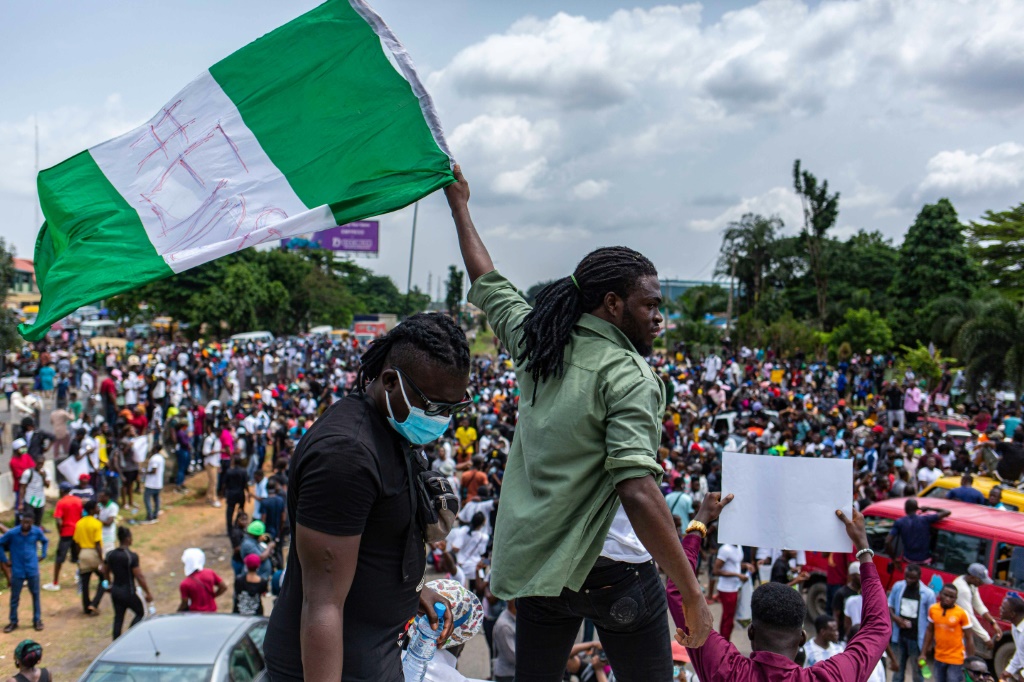 A Nigerian man waves a flag at a protest in Lagos against police brutality