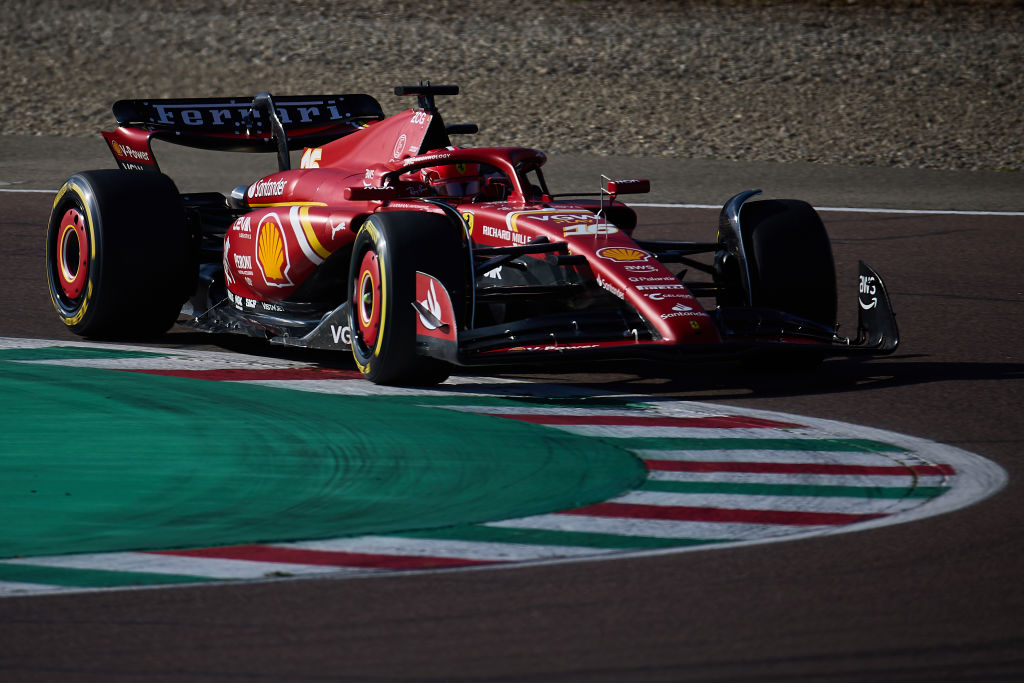 A red Ferrari speeding on a racetrack in Fiorano Modenese