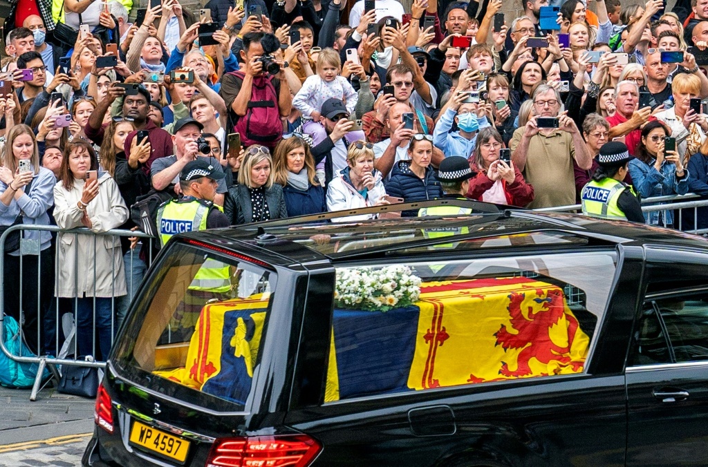 The coffin of Queen Elizabeth II, draped in the Royal Standard of Scotland, being driven through Edinburgh towards the Palace of Holyroodhouse, on September 11, 2022