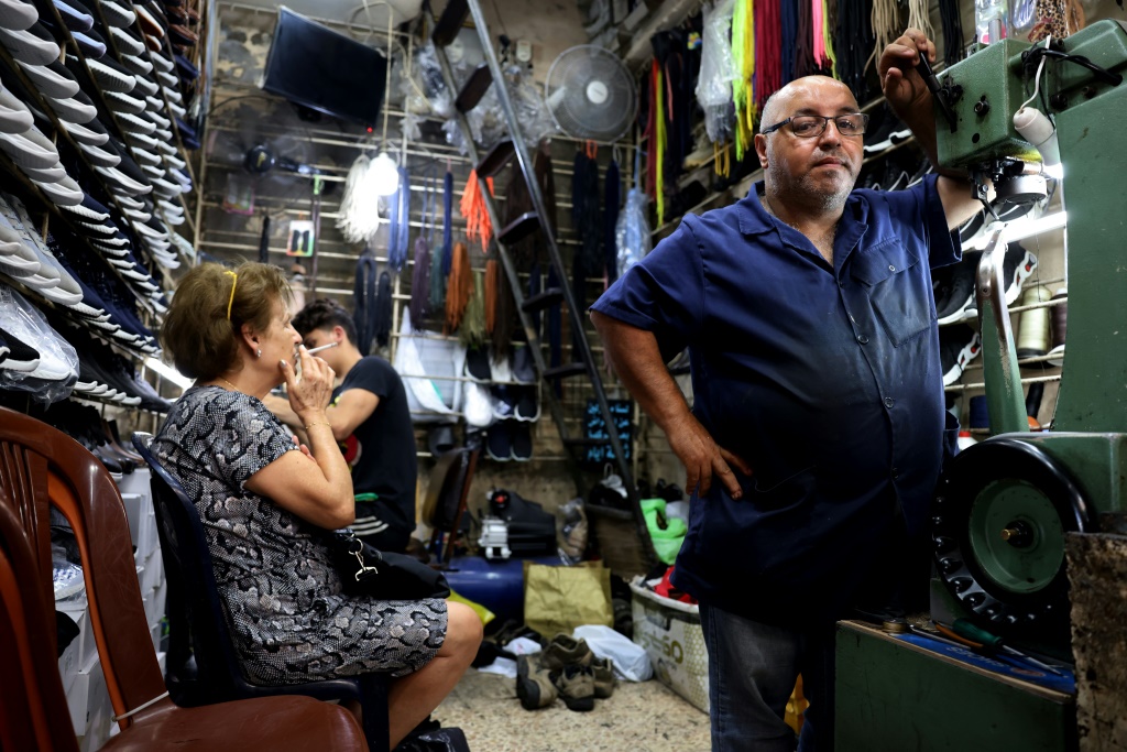 Ahmed al-Bizri's shoe repair store is nestled among old stone arches and a crowded warren of shops and stalls in Sidon