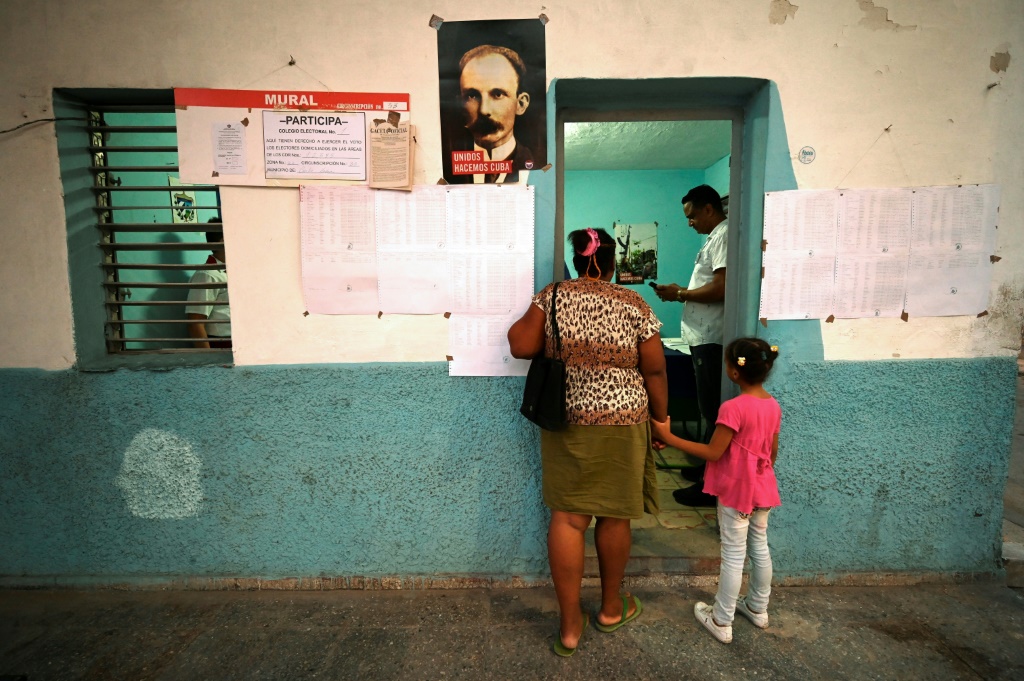 A woman, accompanied by her daughter, waits to vote on the new Family Code at a Havana polling station