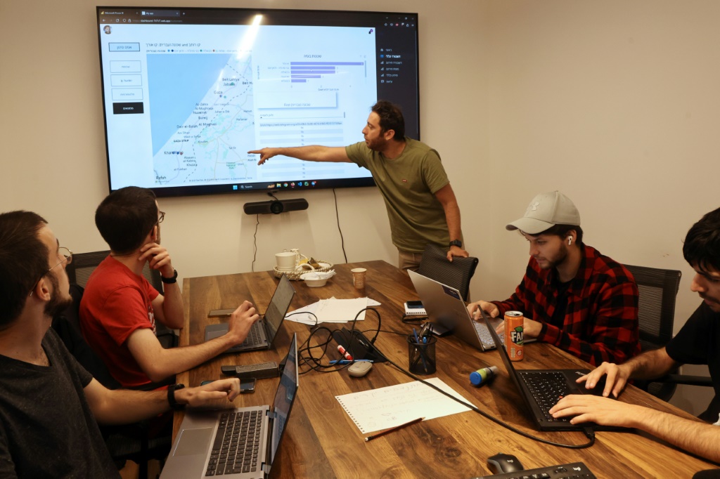 Tech industry volunteers analyse data on missing hostages at an office in Tel Aviv