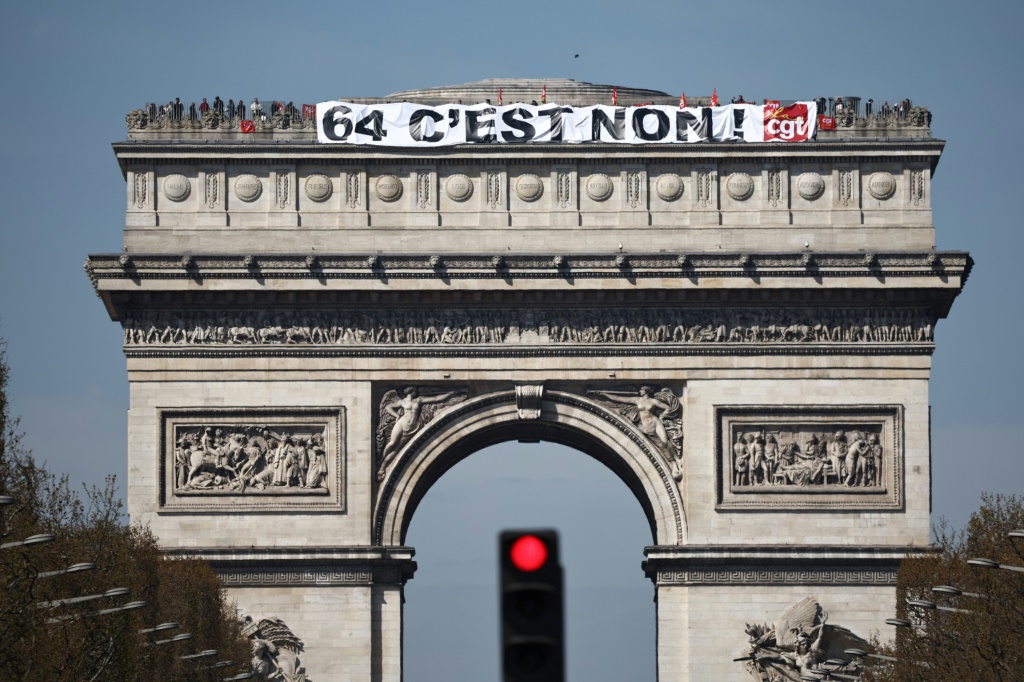Activists unfurled a banner at the top of the capital's landmark Arc de Triomphe, reading 'No to 64'