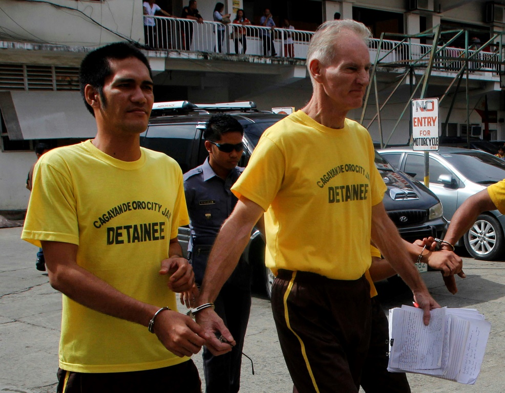 Rapist and sex trafficker Peter Scully  of Australia (R), seen handcuffed to another prisoner in a 2015 file photo, has been sentenced to 129 years in jail