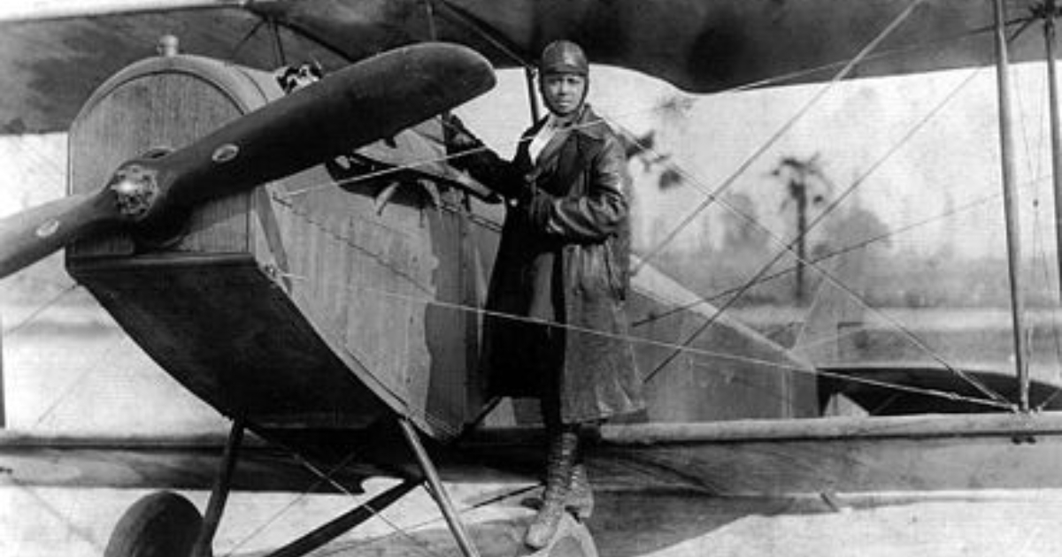 Bessie Coleman poses beside a plane
