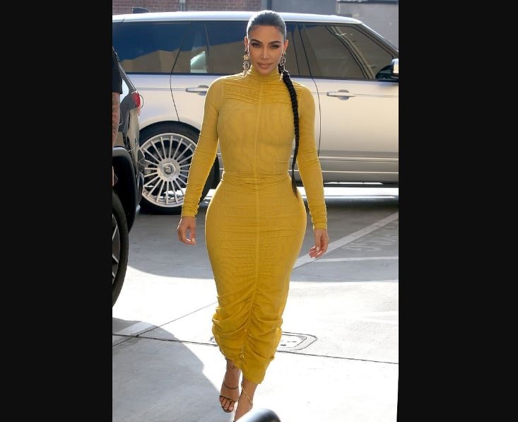 Kim Kardashian stuns in yellow dress as she displays curves