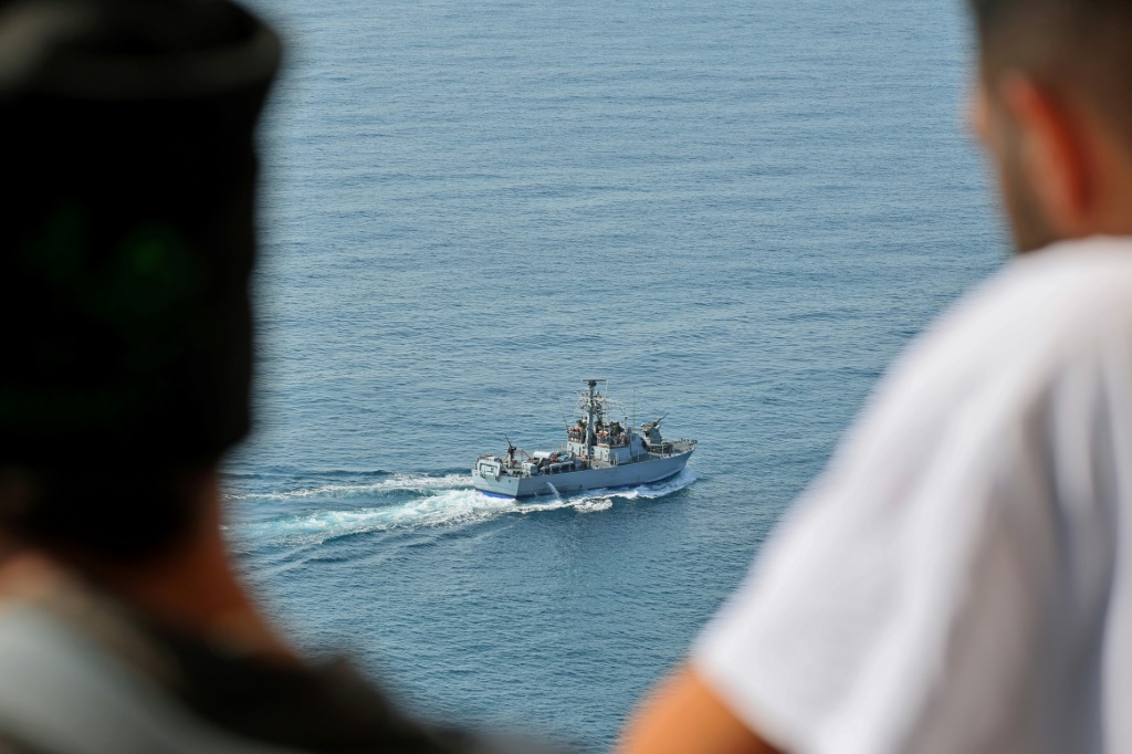 People watch as an Israeli navy fast patrol boat sails in the Mediterranean sea off Rosh HaNikra in northern Israel, close to the border area with Lebanon, ahead of the planned signing of the maritime accord