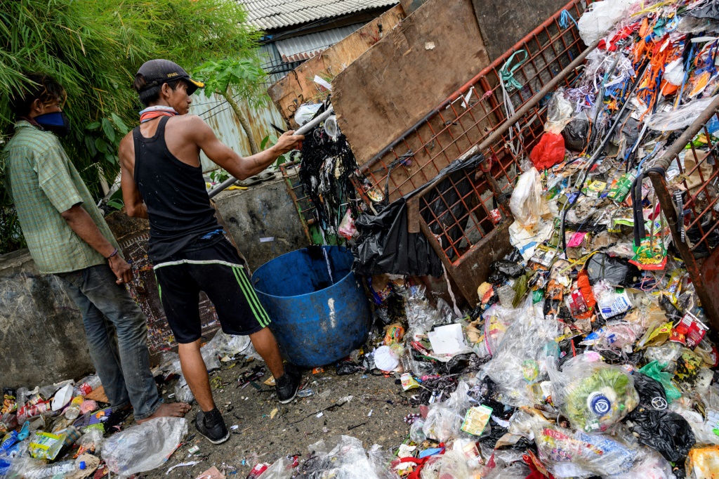 Workers collect trash including plastic waste from a neighbourhood dump site in Jakarta, which does not have a municipal collection system for household waste and has no incineration facilities