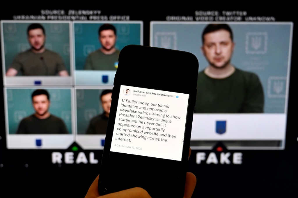 A phone shows a statement from the head of security policy at Meta in front of a fake video of Ukrainian President Volodymyr Zelensky calling on his soldiers to lay down their weapons