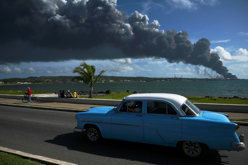 Black smoke from a burning oil tank is seen from a street in Matanzas, Cuba, on August 6, 2022