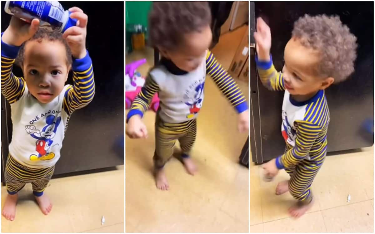 The excited kid danced with a bottle of juice in his hand.