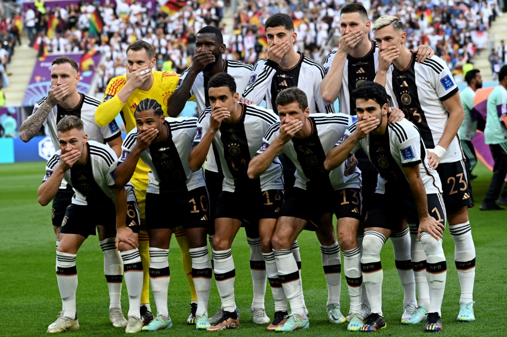 The Germany side cover their mouths as they pose for the team picture ahead of the Qatar 2022 World Cup match against Japan on November 23, 2022