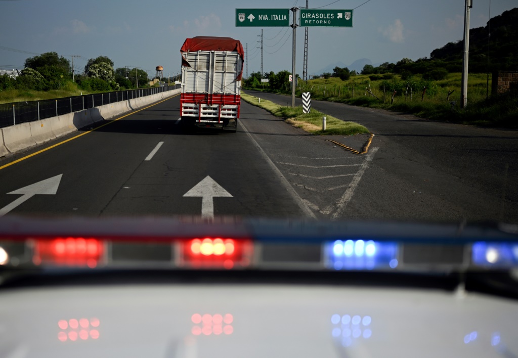 Police escort a truck carrying limes in Mexico's Michoacan state