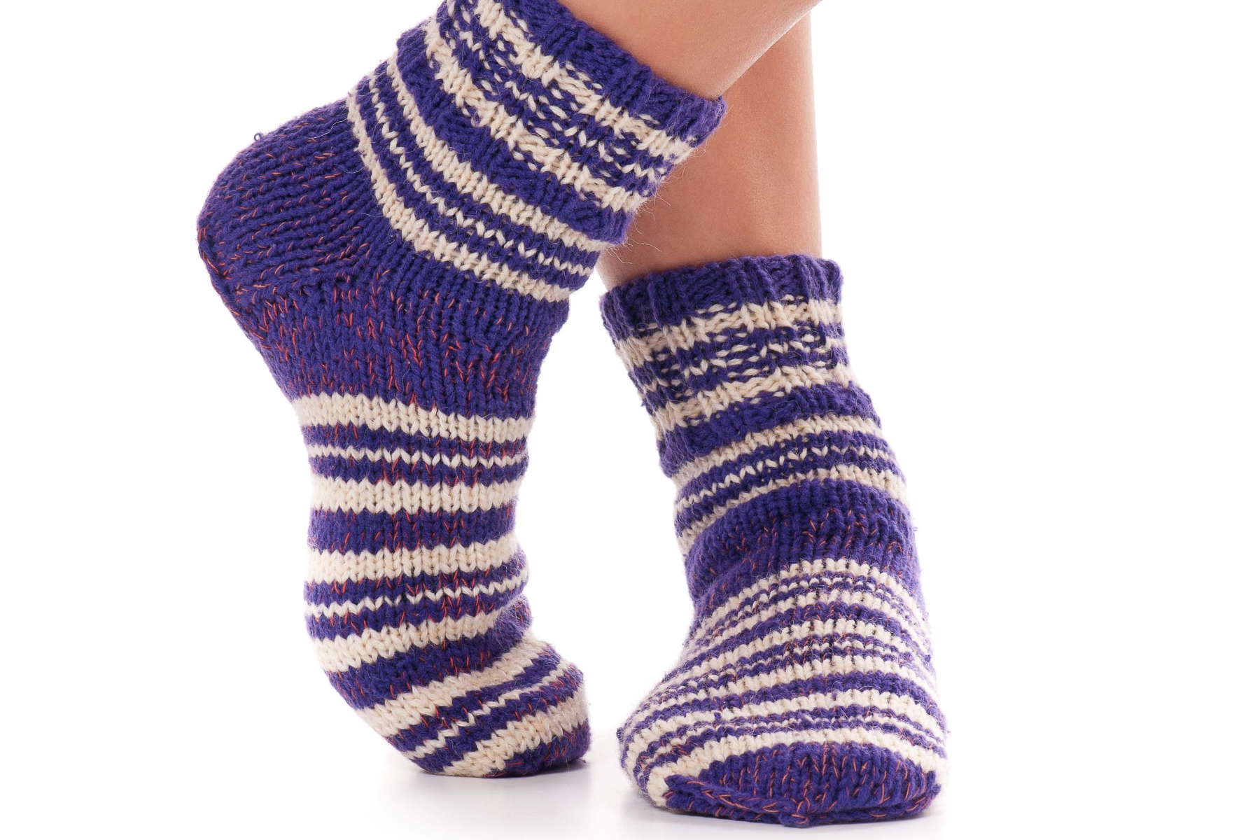 Close-up of criss-crossed legs with a pair of wool socks