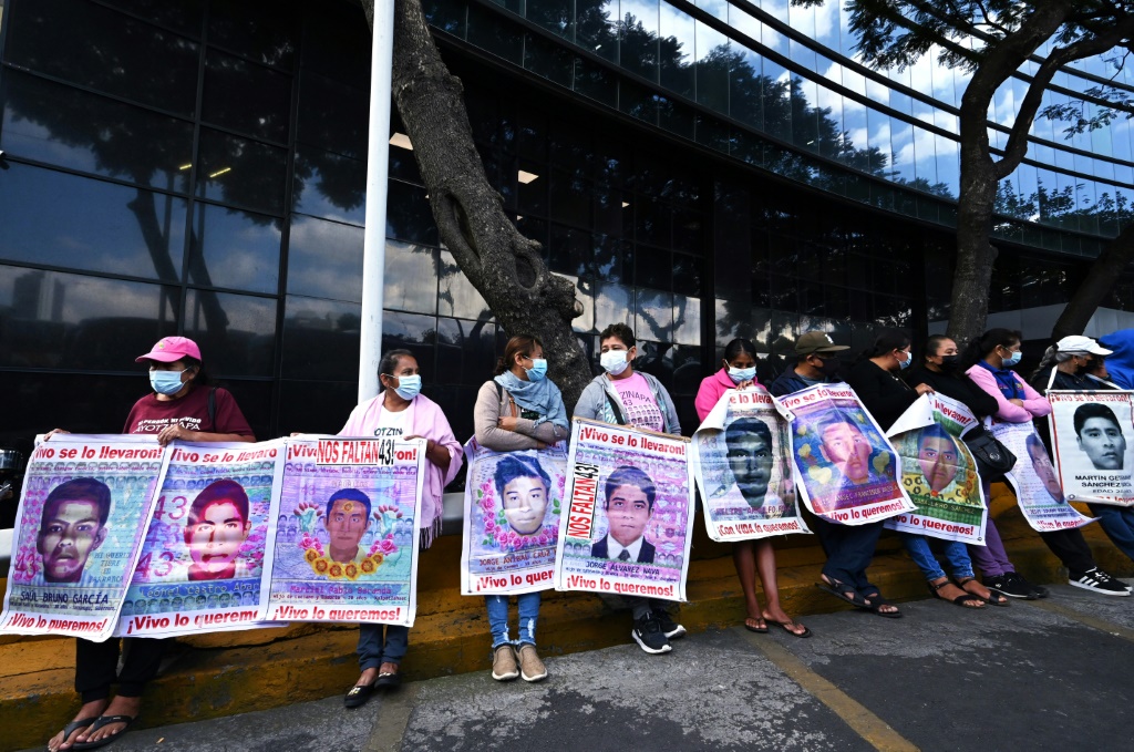 Relatives hold pictures of the missing students at a protest outside the attorney general's office in Mexico City