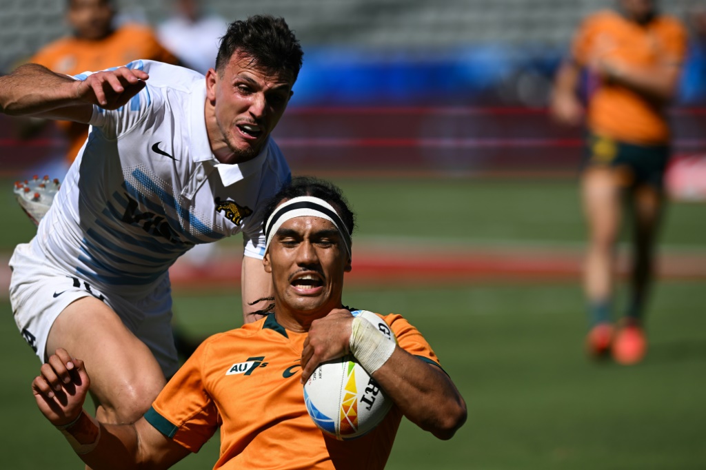 Australia's Dietrich Roache, front, escapes Argentina's Tobias Wade, left, to score a try in a 19-14 victory over the South American side at the World Rugby Sevens series season-ending tournament in Los Angeles
