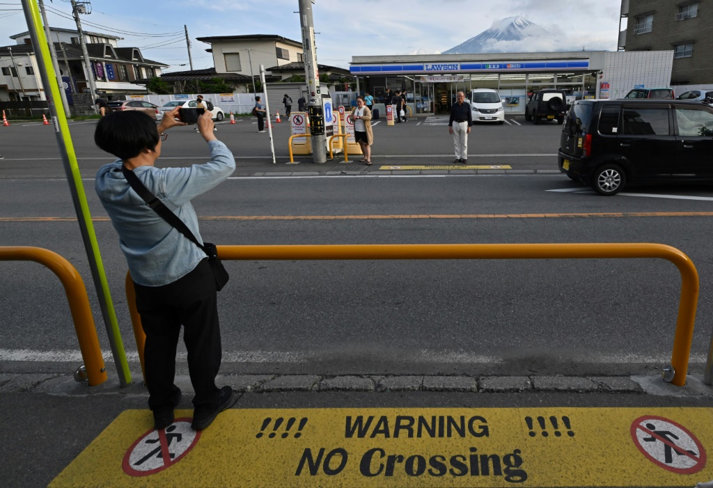 A tourist takes pictures of Mount Fuji in the town of Fujikawaguchiko, Yamanashi prefecture