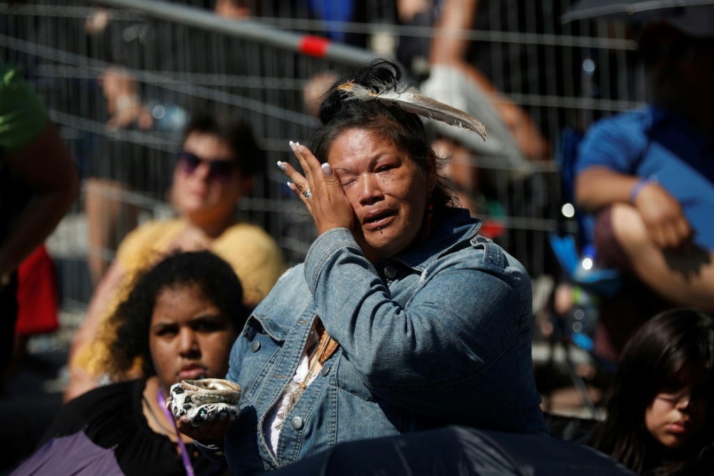 An Indigenous woman cries as Catholic faithful listen to Pope Francis celebrate mass inside the shrine of Sainte-Anne-de-Beaupre in Quebec, Canada
