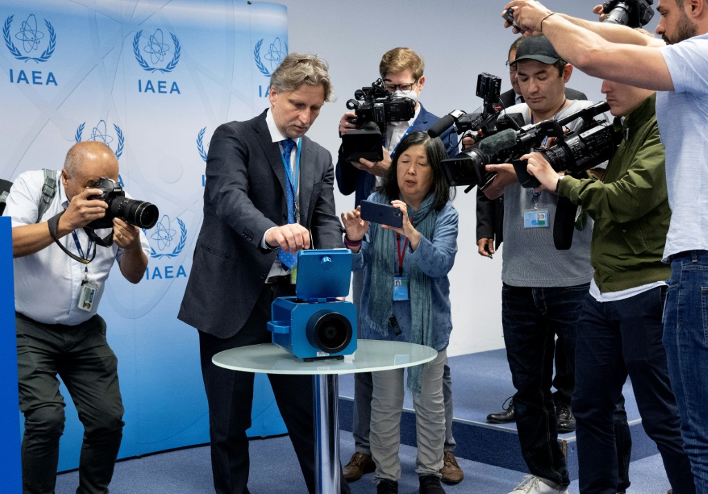 Media watch a demonstration of a monitoring camera used in Iran during a press conference of Rafael Grossi, director general of the International Atomic Energy Agency (IAEA), in June 2022