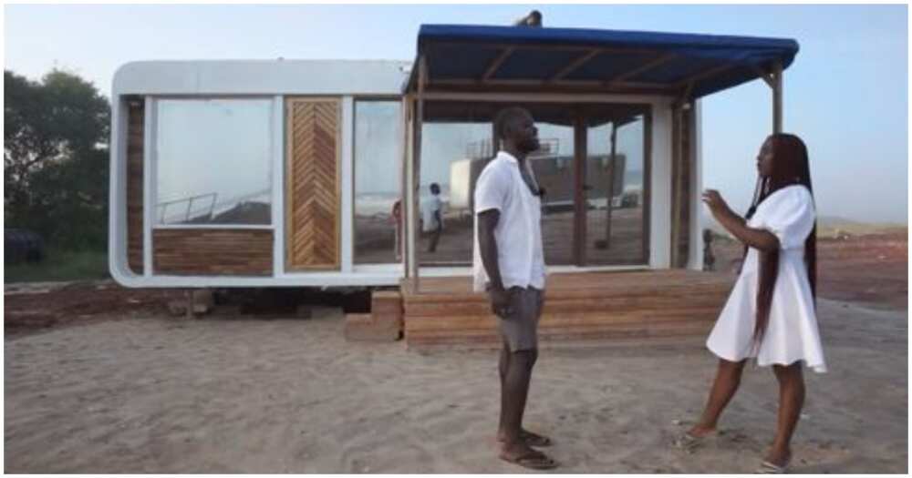 Brown and an interview host stand infront of the transportable house