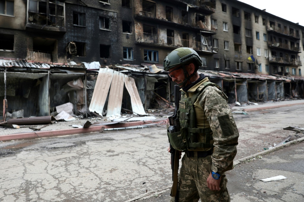 A Ukrainian serviceman passes by destroyed buildings in the town of Siversk, in the Donetsk region on July 22, 2022