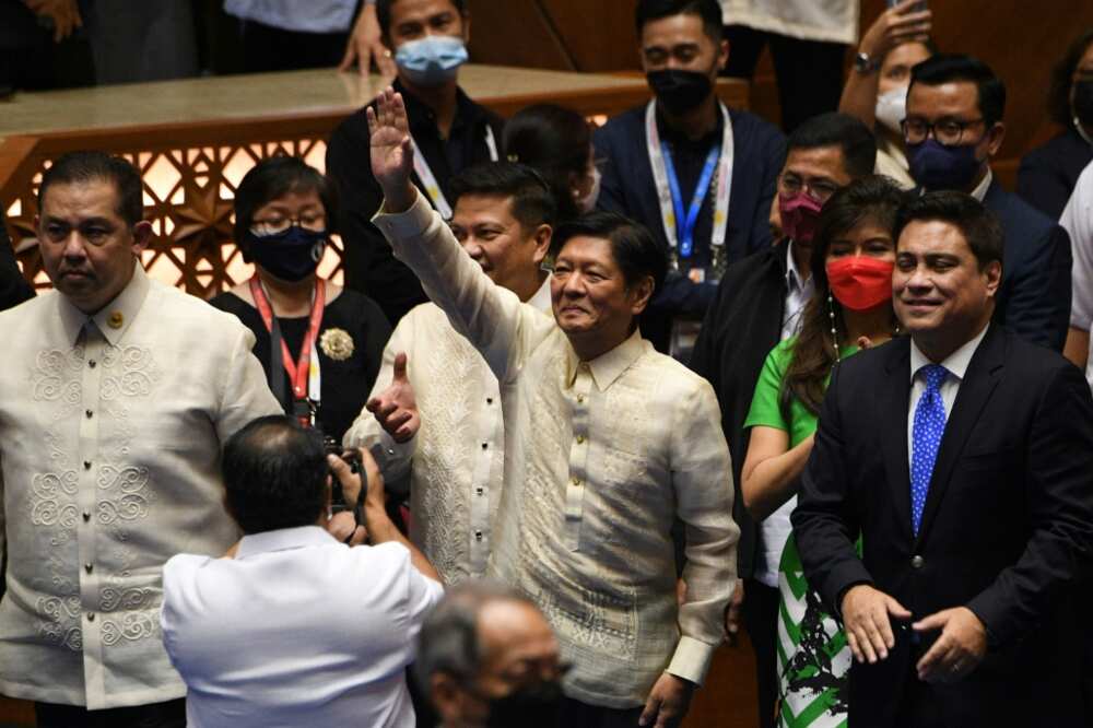 Philippine president-elect Ferdinand Marcos Jr (C) waves to supporters as he arrives for his proclamation as the country's president