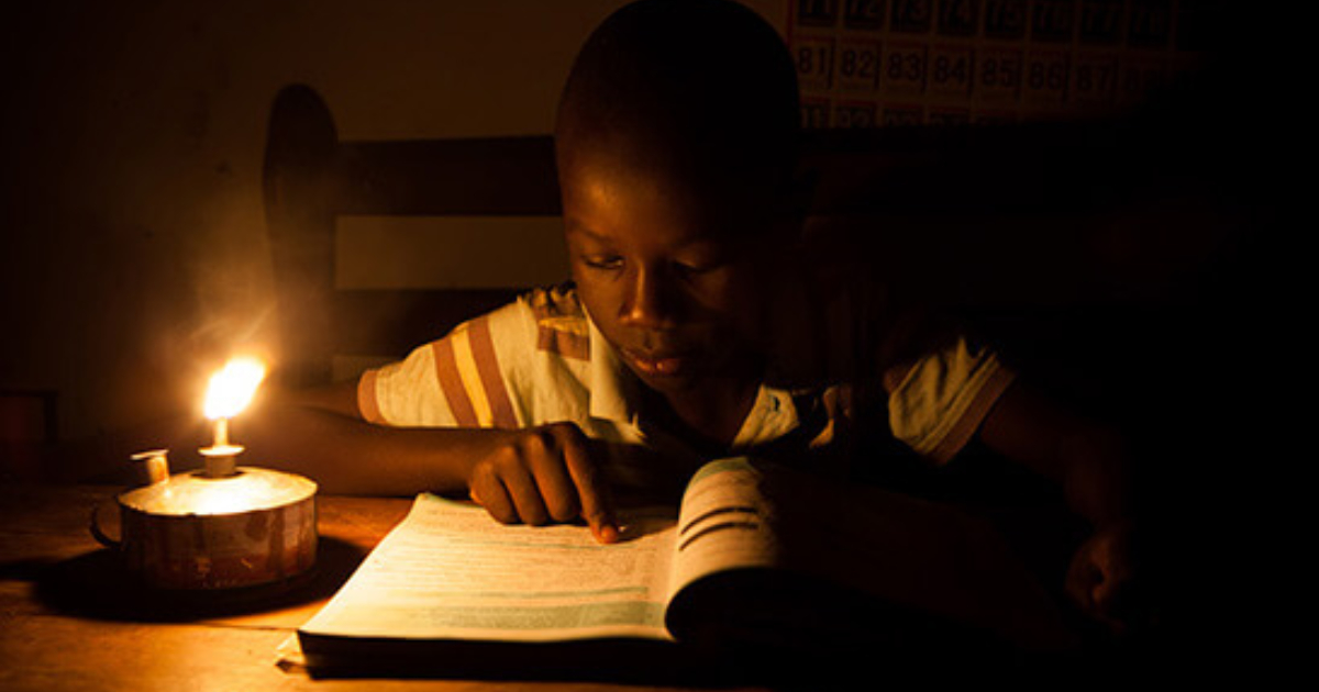 A little boy studying with a lantern