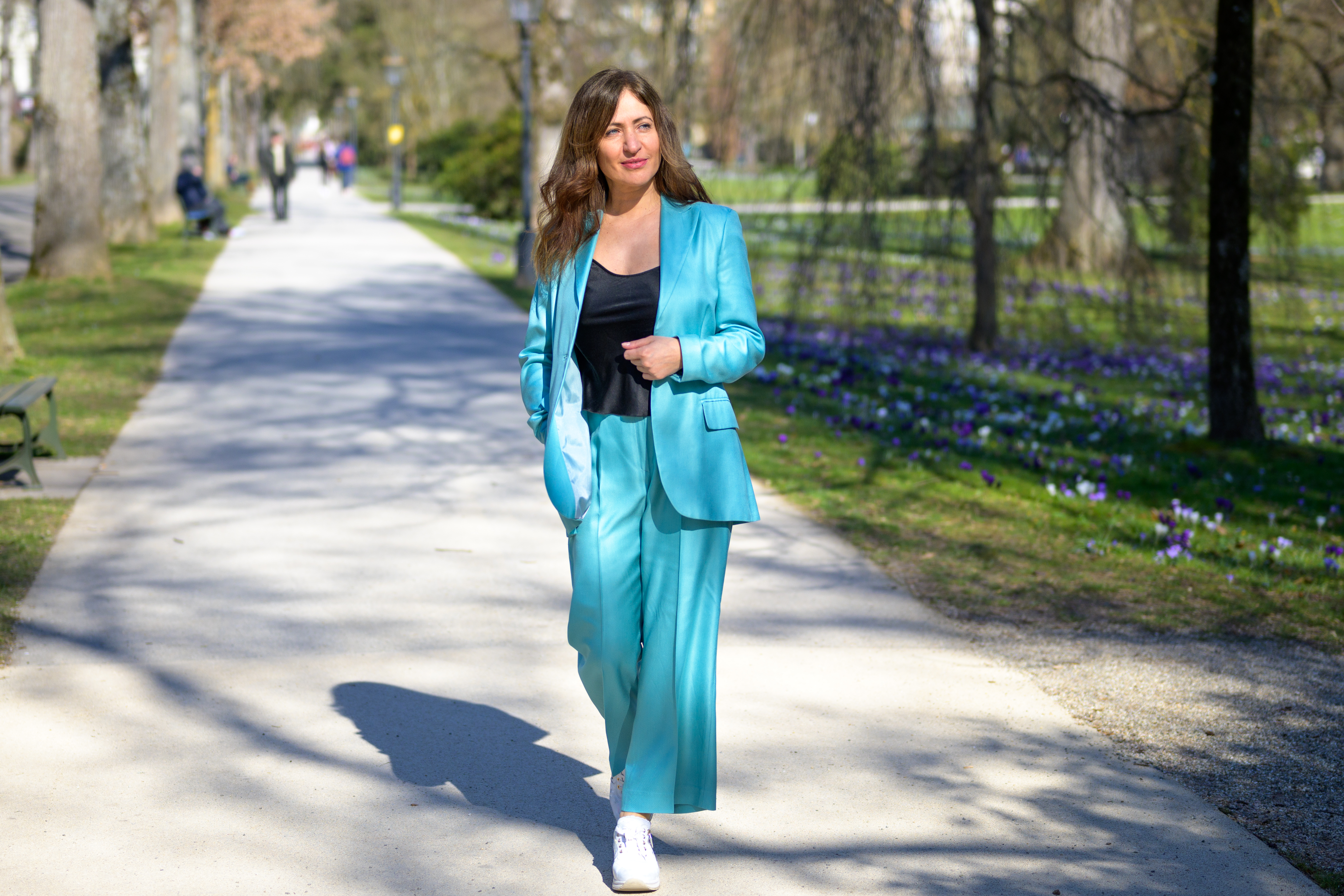 A stylish, attractive middle-aged woman in a turquoise pantsuit
