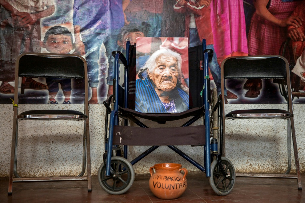 Maria Salud Ramirez is now only present in the photographs placed on her wheelchair and the altar that her family has prepared to receive her spirit on the Day of the Dead