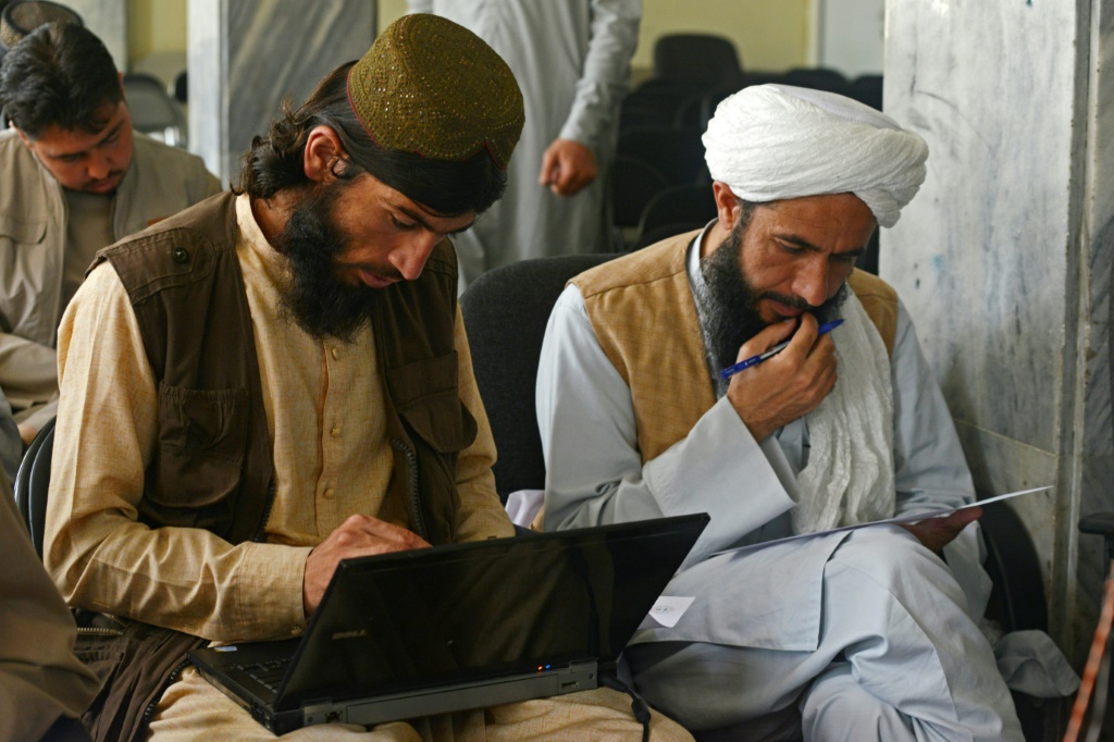 Taliban member Gul Agha Jalali (L) is one of many fighters who have traded combat for the classroom following the group's return to power