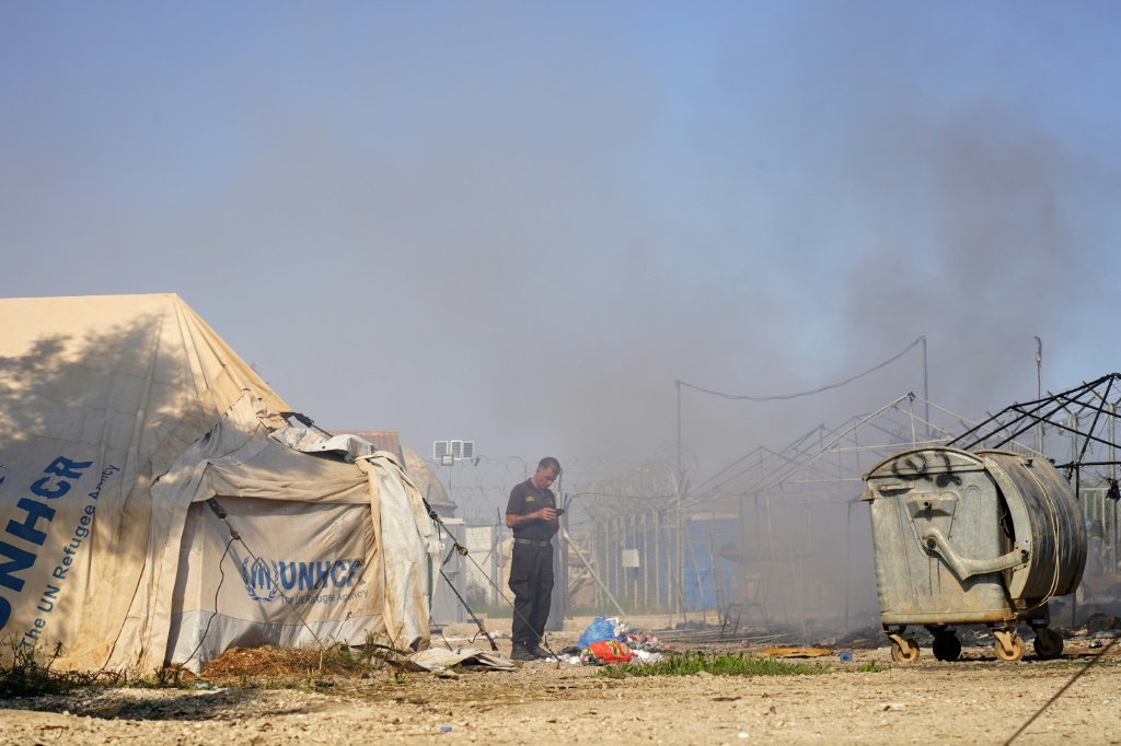 Smoke billows after clashes erputed in a camp for migrants the edge of the Cypriot capital Nicosia on Friday