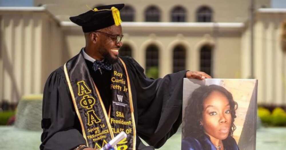 Black Man Poses With A Photo Of His Family Member As He Becomes A Lawyer