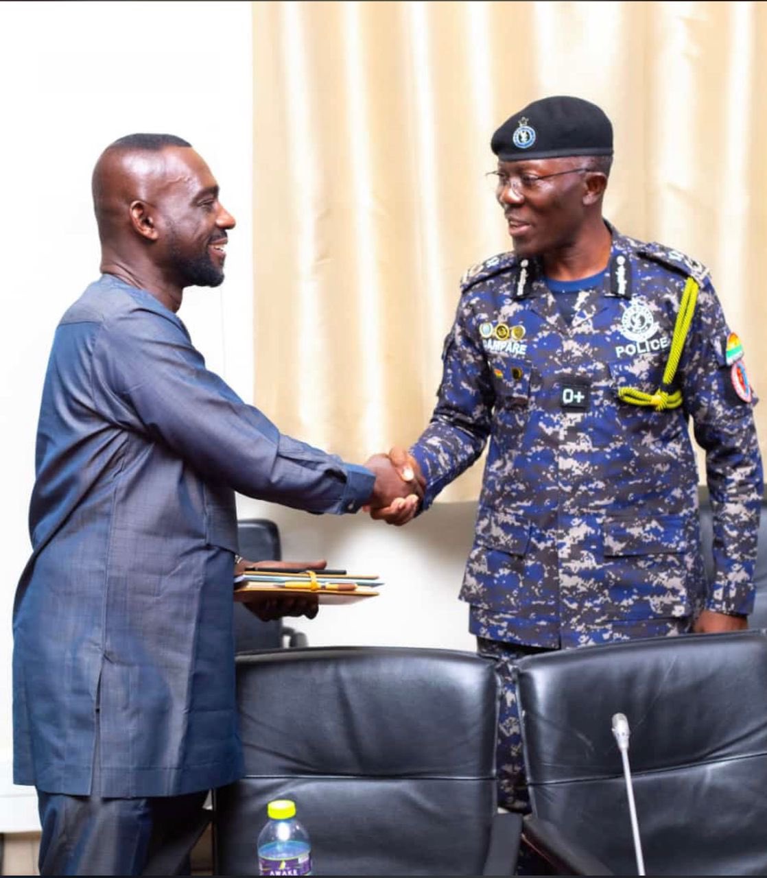 Dampare shakes the hand of COP George Alex Mensah.