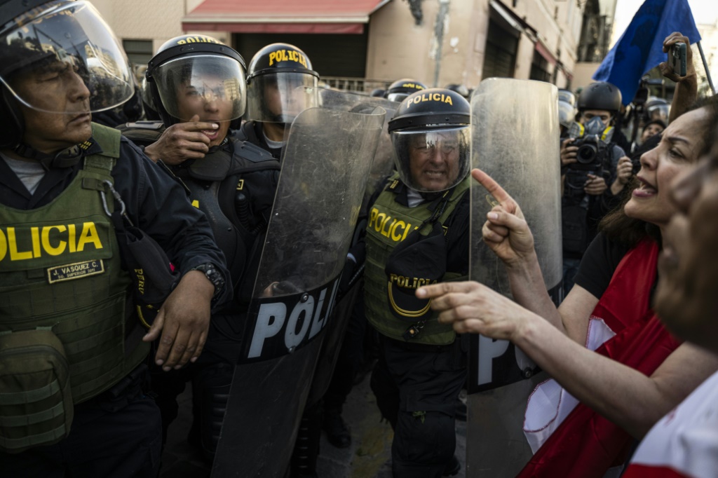 Opponents of Peruvian President Pedro Castillo face off with police during a demonstration in Lima on November 5, 2022