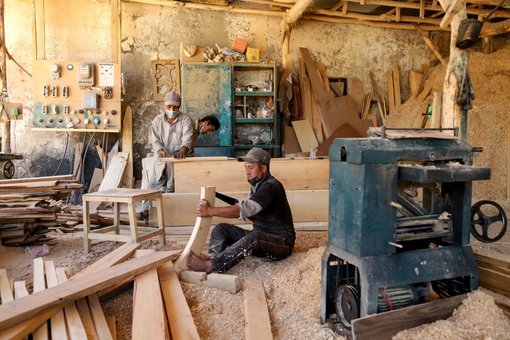 Without a reliable energy supply, carpenters use a fuel generator to keep business in operation, puffing out emissions that contribute to global warming